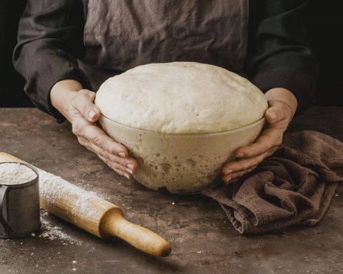 female-chef-holding-bowl-with-pizza-dough